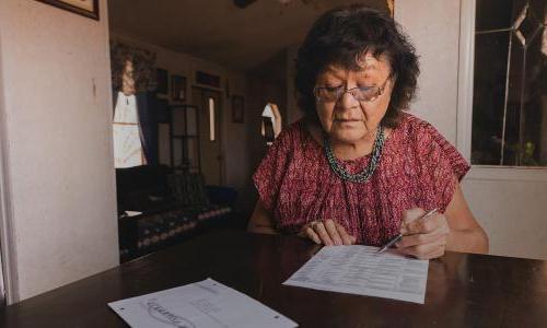 Person filling out a mail-in voting ballot.